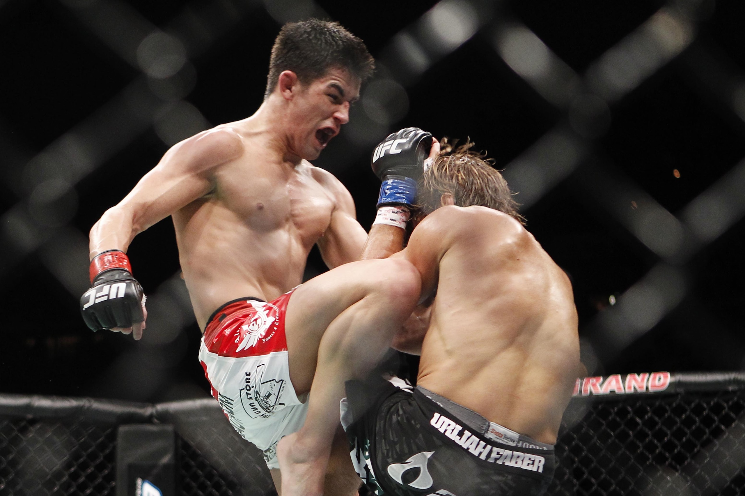 Urijah Faber, left, takes a knee from Dominick Cruz during the fourth round of their UFC bantamweight mixed martial arts title match, Saturday, July 2, 2011 at The MGM Grand Garden Arena in Las Vegas. Cruz won by unanimous decision. (AP Photo/Eric Jamison)