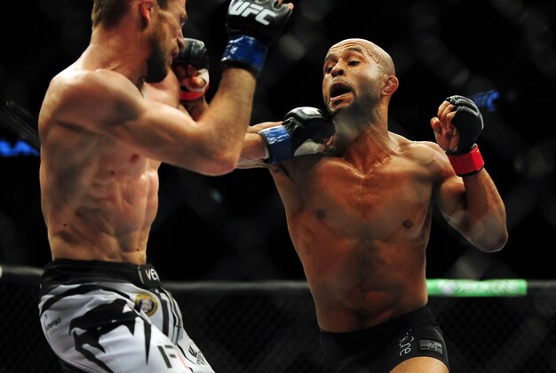 Jun 14, 2014; Vancouver, British Columbia, Canada; Demetrious Johnson (red) fights against Ali Bagautinov (blue) in the flyweight title bout at UFC 174 at Rogers Arena. Mandatory Credit: Anne-Marie Sorvin-USA TODAY Sports