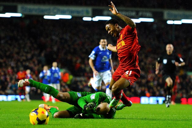 LIVERPOOL, ENGLAND - JANUARY 28:  Raheem Sterling of Liverpool is brought down for a penalty by goalkeeper Tim Howard of Everton during the Barclays Premier League match between Liverpool and Everton at Anfield on January 28, 2014 in Liverpool, England.  (Photo by Laurence Griffiths/Getty Images)