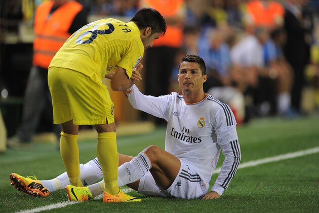 VILLARREAL, SPAIN - SEPTEMBER 14:  Cristiano Ronaldo (R) of Real Madrid is helped up by Jaume Costa of Villarreal during the La Liga match between Villarreal and Real Madrid at El Madrigal on September 14, 2013 in Villarreal, Spain.  (Photo by Denis Doyle/Getty Images)