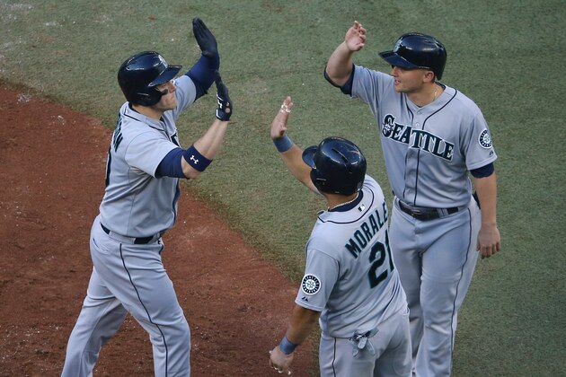 TORONTO, CANADA - SEPTEMBER 25: Logan Morrison #20 of the Seattle Mariners is congratulated by Kendrys Morales #21 and Kyle Seager #15 after hitting a three-run home run in the fourth inning during MLB game action against the Toronto Blue Jays on September 25, 2014 at Rogers Centre in Toronto, Ontario, Canada. (Photo by Tom Szczerbowski/Getty Images)