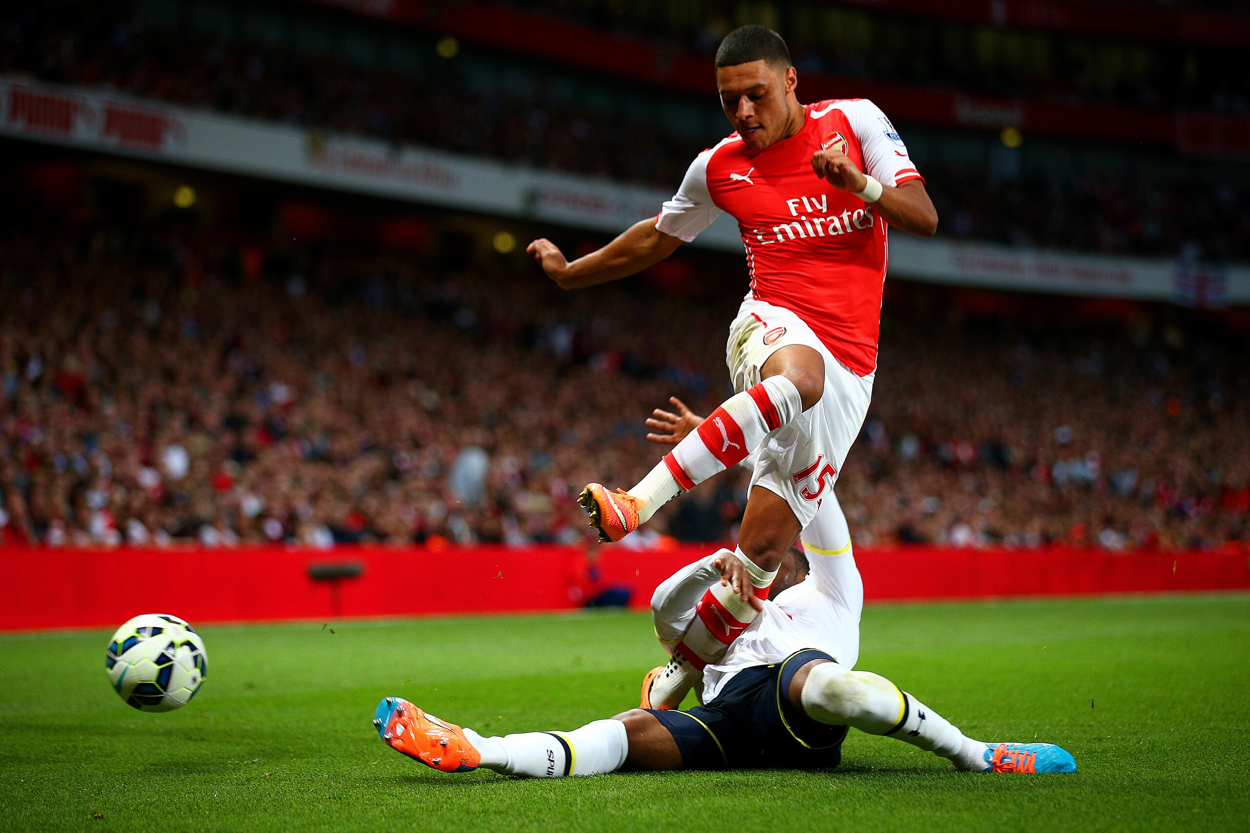 LONDON, ENGLAND - SEPTEMBER 27:  Danny Rose of Spurs tackles Alex Oxlade-Chamberlain of Arsenal during the Barclays Premier League match between Arsenal and Tottenham Hotspur at Emirates Stadium on September 27, 2014 in London, England.  (Photo by Paul Gilham/Getty Images)