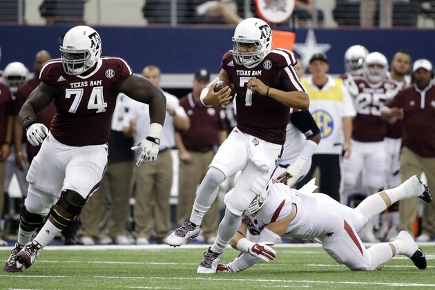 Texas A&M offensive linesman Germain Ifedi (74) provides protection for quarterback Kenny Hill (7) on a running play as Arkansas defensive lineman Karl Roesler attempts the tackle in the first half of an NCAA college football game, Saturday, Sept. 27, 2014, in Arlington, Texas. (AP Photo/Tony Gutierrez)