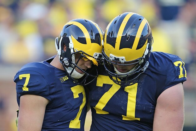 ANN ARBOR, MI - SEPTEMBER 27: Quarterback Shane Morris #7 of the Michigan Wolverines is helped off the field by Ben Braden #71 during the fourth quarter of the game against the Minnesota Golden Gophers at Michigan Stadium on September 27, 2014 in Ann Arbor, Michigan. The Golden Gophers defeated the Wolverines 30-14. (Photo by Leon Halip/Getty Images)