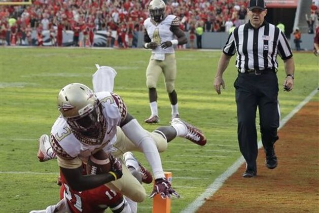 Florida State's Jesus Wilson (3) scores a touchdown as North Carolina State's Juston Burris (11) misses the tackle during the second half of an NCAA college football game in Raleigh, N.C., Saturday, Sept. 27, 2014. Florida State won 56-41.(AP Photo/Gerry Broome)