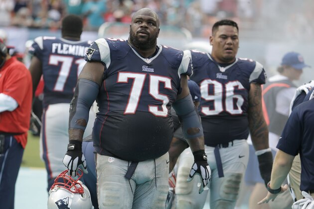 New England Patriots defensive tackle Vince Wilfork (75) looks up at the scoreboard after the Miami Dolphins scored in the second half of an NFL football game, Sunday, Sept. 7, 2014, in Miami Gardens, Fla. The Dolphins defeated the Patriots 33-20. At right is defensive tackle Sealver Siliga (96). (AP Photo/Lynne Sladky)