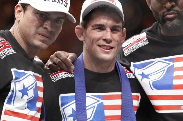 Dominick Cruz, center, poses with the belt after his victory over Urijah Faber in their UFC bantamweight mixed martial arts title match, Saturday, July 2, 2011 at The MGM Grand Garden Arena in Las Vegas. Cruz won by unanimous decision. (AP Photo/Eric Jamison)