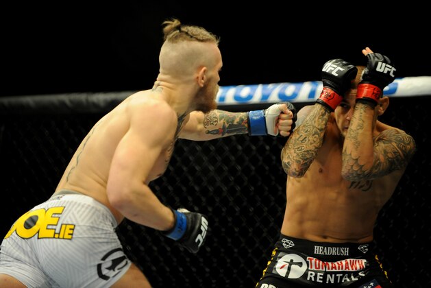 Sep 27, 2014; Las Vegas, NV, USA; Conor McGregor (blue gloves) fights Dustin Poirier (red gloves) during a featherweight fight during UFC 178 at MGM Grand Garden Arena. Mandatory Credit: Stephen R. Sylvanie-USA TODAY Sports