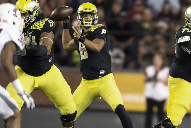 Oregon quarterback Marcus Mariota (8) throws a pass to wide receiver Devon Allen against Washington State during the first quarter of an NCAA college football game Saturday, Sept. 20, 2014, in Pullman, Wash. (AP Photo/Dean Hare)