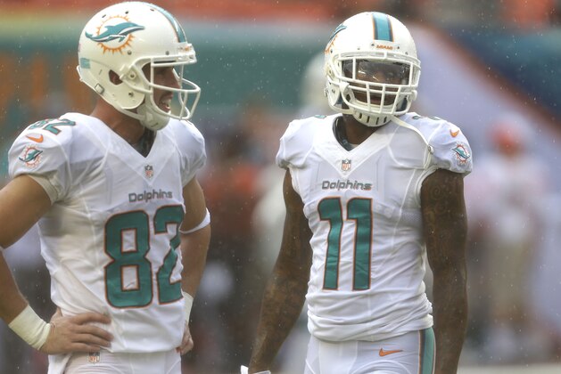 Miami Dolphins wide receivers Brian Hartline (82) and Mike Wallace (11) talk as a steady rain falls before an NFL football game against the Atlanta Falcons, Sunday, Sept. 22, 2013 in Miami Gardens, Fla. (AP Photo/Wilfredo Lee)