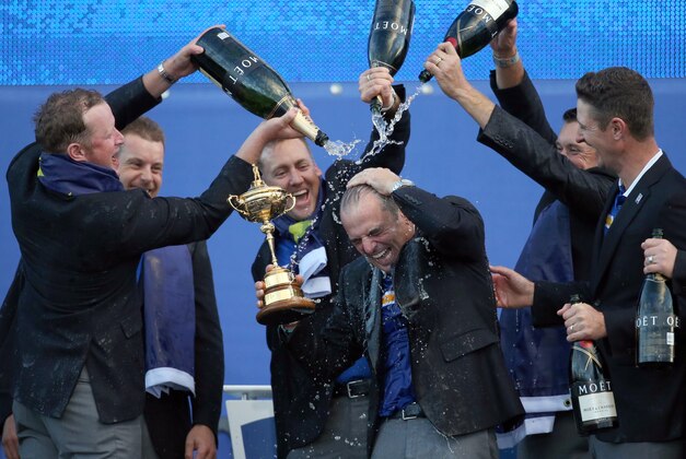 From left, Europe's players Jamie Donaldson, Henrik Stenson, Ian Poulter, Lee Westwood and Justin Rose pour champagne over captain Paul McGinley as they celebrate winning the 2014 Ryder Cup golf tournament, at Gleneagles, Scotland, Sunday, Sept. 28, 2014. (AP Photo/Scott Heppell)