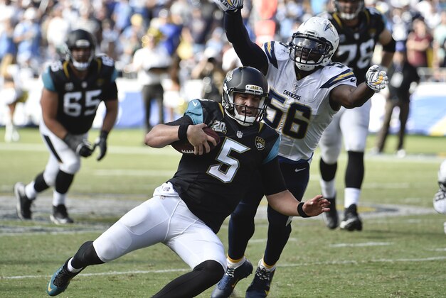 Jacksonville Jaguars quarterback Blake Bortles goes into a slide as he is pursued by San Diego Chargers linebacker Donald Butler during the second half of an NFL football game Sunday, Sept. 28, 2014, in San Diego.  (AP Photo/Denis Poroy)