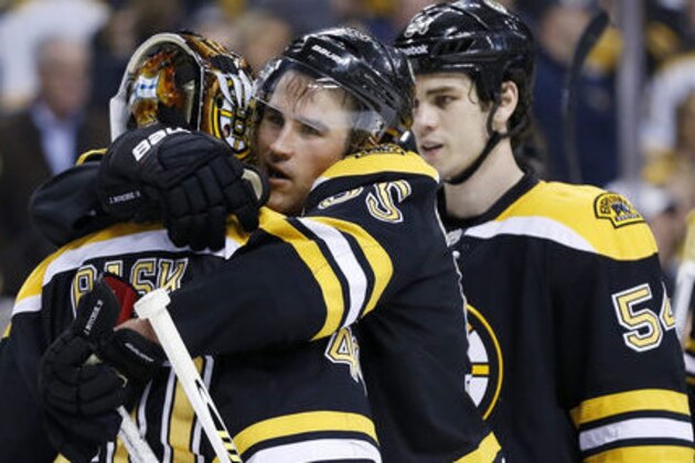 Boston Bruins' Johnny Boychuk (55) hugs goalie Tuukka Rask (40), of Finland, in front of teammates Adam McQuaid (54) and Zdeno Chara (33), of Slovakia, after the Bruins defeated the Philadelphia Flyers 3-0 in an NHL hockey game in Boston, Saturday, March 9, 2013. (AP Photo/Michael Dwyer)