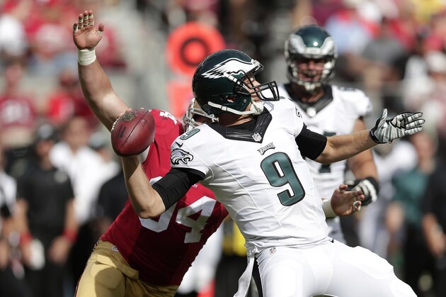 Philadelphia Eagles quarterback Nick Foles (9) passes as San Francisco 49ers defensive tackle Justin Smith applies pressure from behind during the second half of an NFL football game in Santa Clara, Calif., Sunday, Sept. 28, 2014. (AP Photo/Marcio Jose Sanchez)