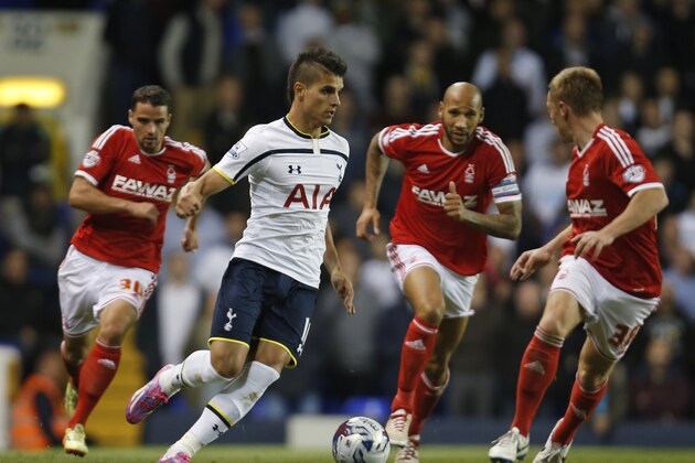 Tottenham Hotspur's Erik Lamela of Argentina dribbles past Nottingham Forest's players during an English League Cup soccer match at the White Hart Lane ground, in London, Wednesday, Sept. 24, 2014. Tottenham Hotspur won the match 3-1. (AP Photo/Lefteris Pitarakis)