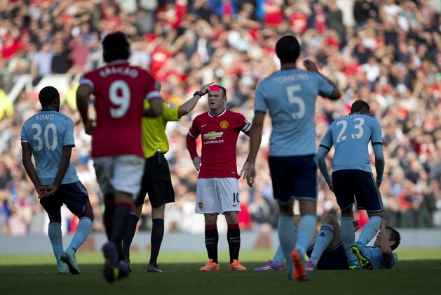 Manchester United's Wayne Rooney, centre, is shown a red card by referee Lee Mason during his team's English Premier League soccer match against West Ham United at Old Trafford Stadium, Manchester, England, Saturday Sept. 27, 2014. (AP Photo/Jon Super)