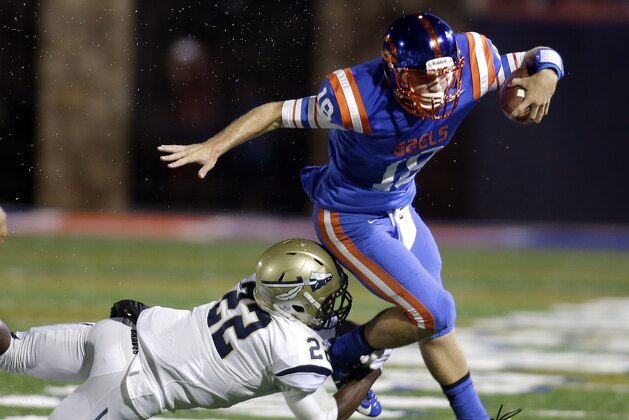 Bishop Gorman quarterback Tate Martell is tackled by St. John Bosco's Clifford Simms during the first half of a high school football game Friday, Sept. 26, 2014, in Las Vegas. (AP Photo/Isaac Brekken)