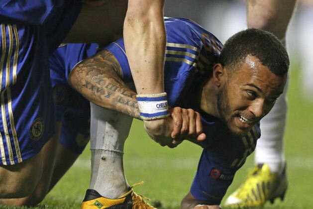Chelsea's Ryan Bertrand is helped up from the ground by a teammate as he plays against Rubin Kazan during the Europa League quarterfinal, first leg soccer match between Chelsea and Rubin Kazan at Chelsea's Stamford Bridge stadium in London, Thursday, April  4, 2013. (AP Photo/Alastair Grant)