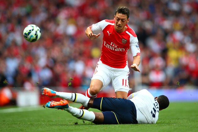 LONDON, ENGLAND - SEPTEMBER 27:  Mesut Oezil of Arsenal in action against Danny Rose of Spurs during the Barclays Premier League match between Arsenal and Tottenham Hotspur at Emirates Stadium on September 27, 2014 in London, England.  (Photo by Paul Gilham/Getty Images)