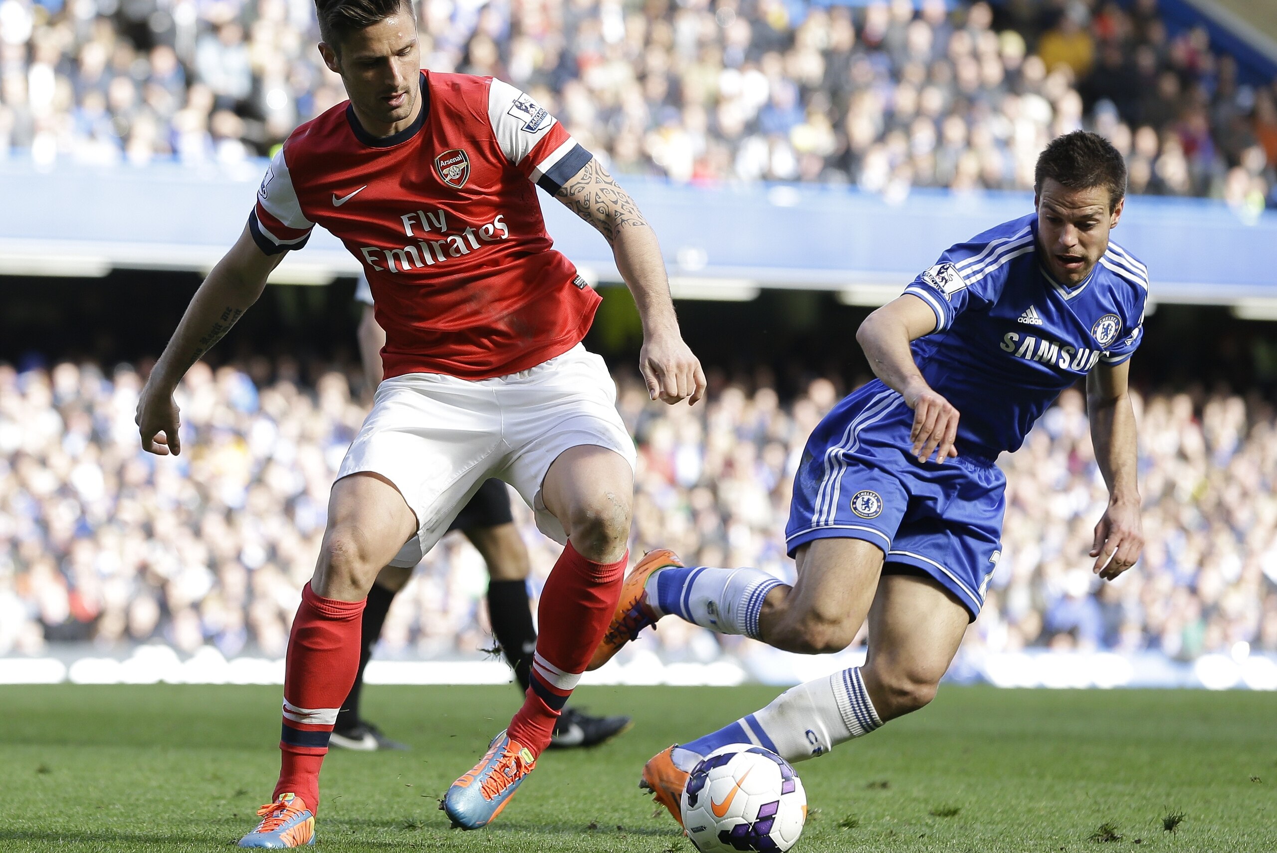 Chelsea's Cesar Azpilicueta, right, and Arsenal's Olivier Giroud vie for the ball during the English Premier League soccer match between Chelsea and Arsenal at Stamford Bridge stadium in London, Saturday, March 22, 2014. (AP Photo/Kirsty Wigglesworth)
