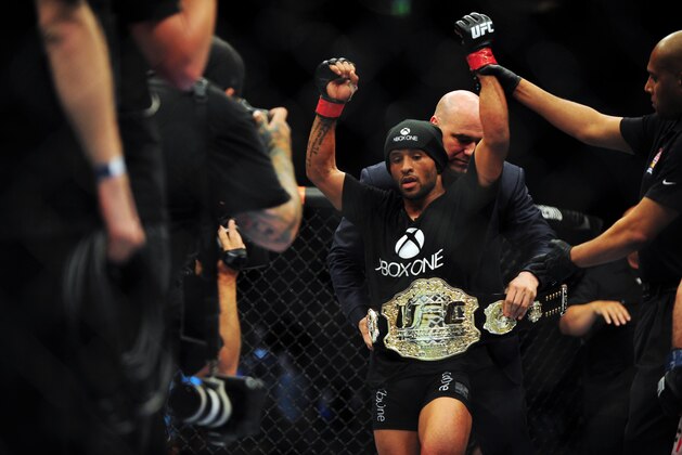 Jun 14, 2014; Vancouver, British Columbia, Canada; Demetrious Johnson (red) reacts after defeating Ali Bagautinov (blue) in the flyweight title bout at UFC 174 at Rogers Arena. Mandatory Credit: Anne-Marie Sorvin-USA TODAY Sports