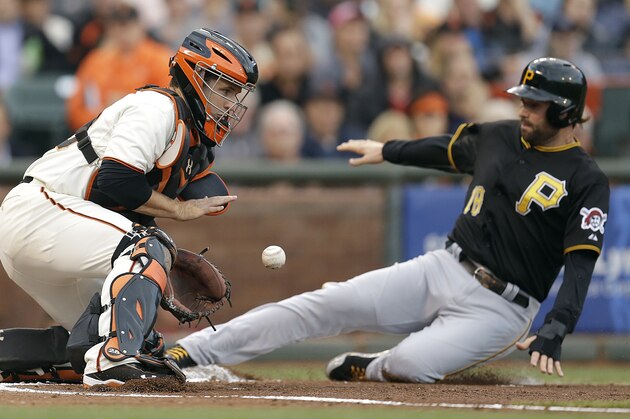 Pittsburgh Pirates' Neil Walker, right, slides to score as San Francisco Giants catcher Buster Posey waits for the ball in the first inning of a baseball game Monday, July 28, 2014, in San Francisco. Walker scored on a sacrifice fly by Pittsburgh's Gregory Polanco(AP Photo/Ben Margot)