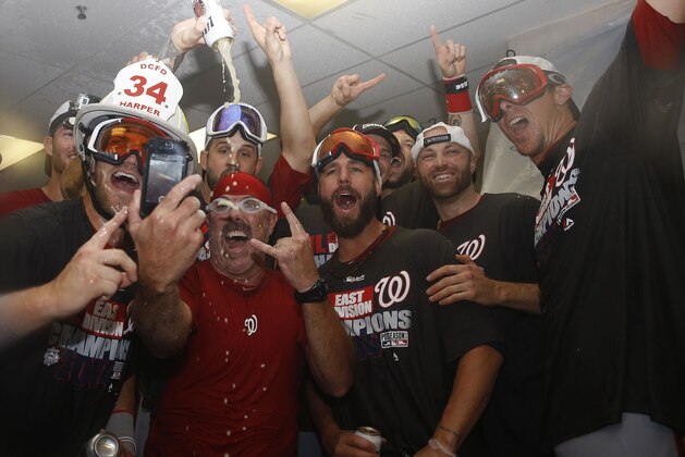 ATLANTA, GA - SEPTEMBER 16: Left fielder Bryce Harper #34 (left), outfielder Kevin Frandsen #19 (center), outfielder Nate Schierholtz #17 (second from right) and other members of the Washington Nationals celebrate in the locker room after the division-clinching game against the Atlanta Braves at Turner Field on September 16, 2014 in Atlanta, Georgia. (Photo by Mike Zarrilli/Getty Images) ATLANTA, GA - SEPTEMBER 16: Left fielder Bryce Harper #34 (left), outfielder Kevin Frandsen #19 (center), outfielder Nate Schierholtz #17 (second from right) and other members of the Washington Nationals celebrate in the locker room after the division-clinching game against the Atlanta Braves at Turner Field on September 16, 2014 in Atlanta, Georgia. (Photo by Mike Zarrilli/Getty Images)