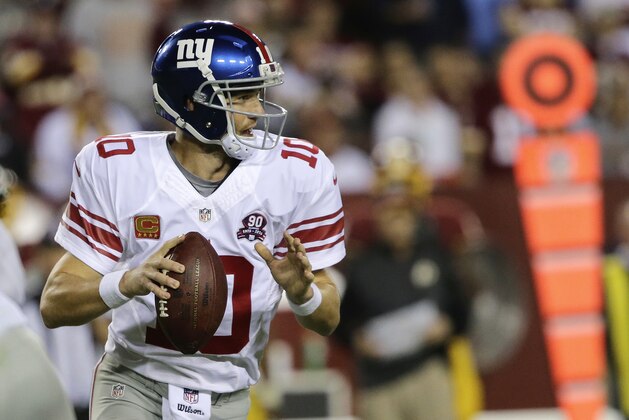 New York Giants quarterback Eli Manning (10) looks foe an opening to pass during the first half of an NFL Thursday night football game against the Washington Redskins in Landover, Md., Thursday, Sept. 25, 2014. (AP Photo/Mark Tenally)