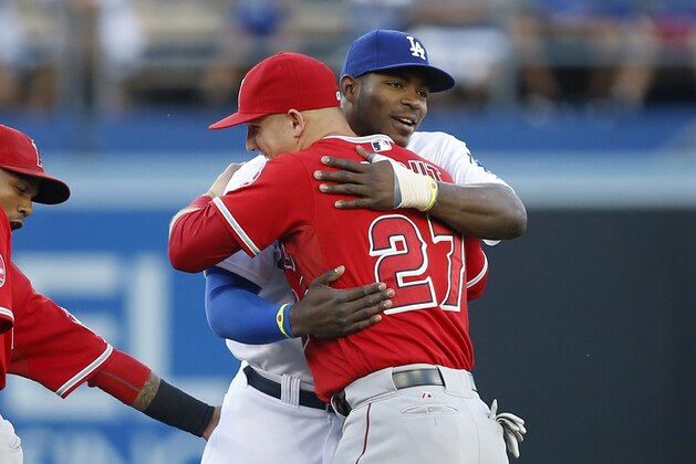 Los Angeles Angels' Mike Trout, left, and Los Angeles Dodgers' Yasiel Puig embrace before a baseball game, Monday, August 4, 2014, in Los Angeles. (AP Photo/Danny Moloshok)