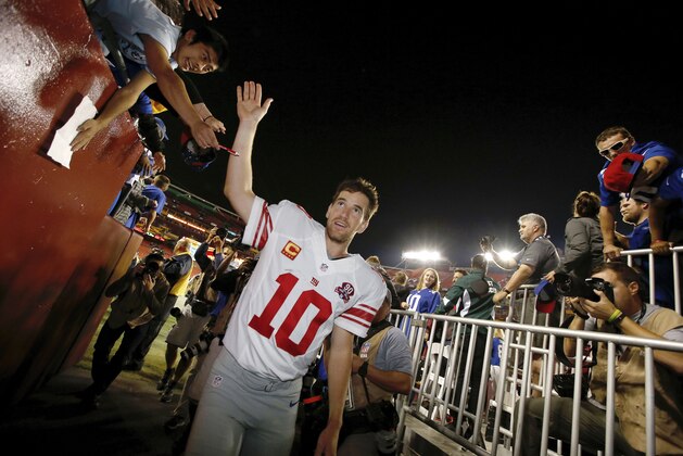 New York Giants quarterback Eli Manning (10) leaves the field after an NFL football game against the Washington Redskins in Landover, Md., Thursday, Sept. 25, 2014. The Giants defeated the Redskins 45-14. (AP Photo/Alex Brandon)