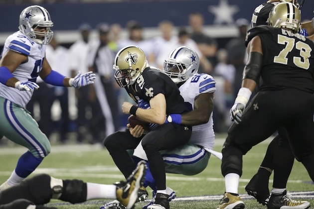 New Orleans Saints quarterback Drew Brees (9) is sacked by Dallas Cowboys' Henry Melton as the Saints' Jahri Evans (73) and the Cowboys' Jeremy Mincey (92) watch during the second half of an NFL football game, Sunday, Sept. 28, 2014, in Arlington, Texas. The Cowboys won 38-17.  (AP Photo/Tim Sharp)