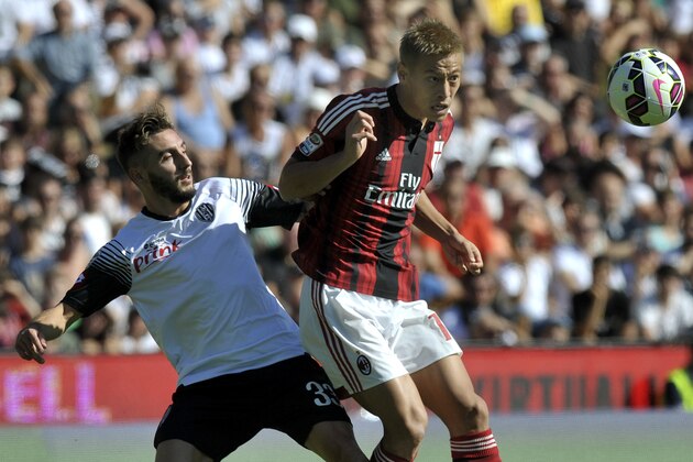 Cesena's Francesco Renzetti, left, vies for the ball with AC Milan's Keisuke Honda of Japan, during their Serie A soccer match at Cesena's Manuzzi stadium, Italy, Sunday, Sept. 28, 2014. (AP Photo/Marco Vasini)