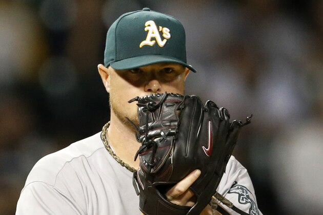 Oakland Athletics starting pitcher Jon Lester checks the runner at first during the third inning of a baseball game against the Chicago White Sox, Tuesday, Sept. 9, 2014, in Chicago. (AP Photo/Charles Rex Arbogast)