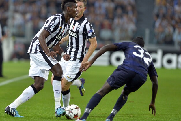 Juventus' Paul Pogba controls the ball as Malmo's Pa Konate faces him, during a Champions League, Group A soccer match between Juventus and Malmo, at the Juventus Stadium in Turin, Italy, Tuesday, Sept. 16, 2014. (AP Photo/Massimo Pinca)