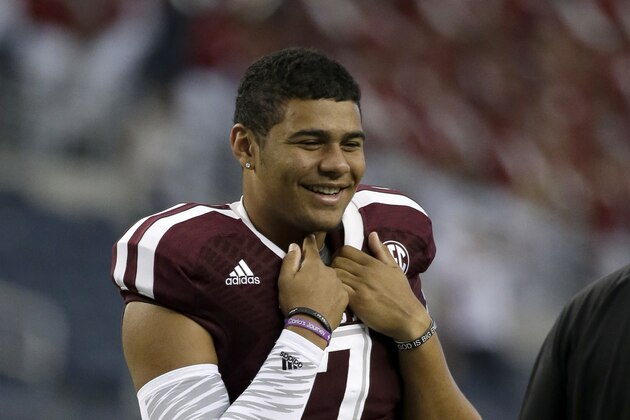 Texas A&M quarterback Kenny Hill smiles as he talks with a teammate on the field before an NCAA college football game against Arkansas, Saturday, Sept. 27, 2014, in Arlington, Texas. (AP Photo/Tony Gutierrez)