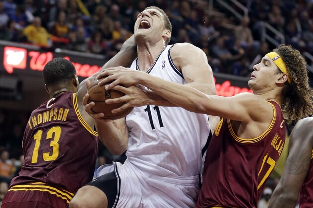 Brooklyn Nets' Brook Lopez (11) is stopped by Cleveland Cavaliers' Tristan Thompson (13) and Anderson Varejao as Lopez tries to go to the basket during the third quarter of an NBA basketball game Wednesday, Oct. 30, 2013, in Cleveland. The Cavaliers won 98-94. (AP Photo/Tony Dejak)