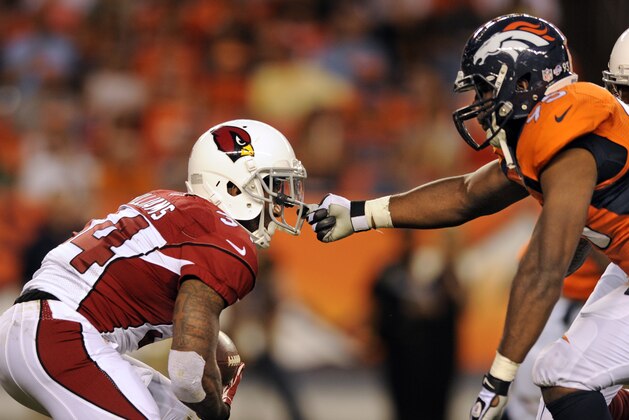 Denver Broncos defensive end Derek Wolfe (95) grabs the face mask of Arizona Cardinals running back Ryan Williams (34)  during a pre-season NFL football game on Thursday, Aug. 29, 2013, in Denver. (AP Photo/Jack Dempsey)