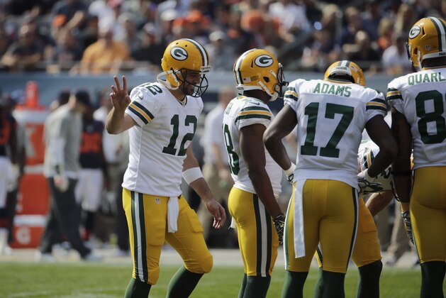 Green Bay Packers quarterback Aaron Rodgers (12) heads to the huddle with his offense in the first half of an NFL football game against the Chicago Bears Sunday, Sept. 28, 2014, in Chicago. (AP Photo/Charles Rex Arbogast)