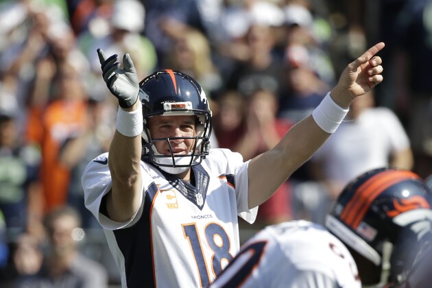 Denver Broncos quarterback Peyton Manning signals to his team in the first half of an NFL football game against the Seattle Seahawks, Sunday, Sept. 21, 2014, in Seattle. (AP Photo/Elaine Thompson)