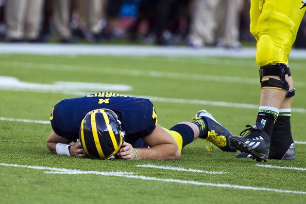In this Sept. 27, 2014, photo, Michigan quarterback Shane Morris lays on the field after taking a hit in the fourth quarter of an NCAA college football game against Michigan in Ann Arbor, Mich. Early Tuesday, Sept. 30, 2014, roughly 12 hours after embattled Michigan coach Brady Hoke said he'd been given no indication that Morris had been diagnosed with a concussion, athletic director Dave Brandon revealed in a post-midnight statement that the sophomore did appear to have sustained one. (AP Photo/Tony Ding)