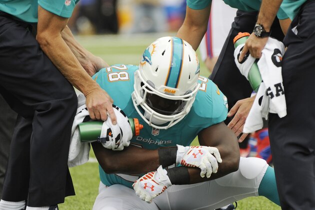 Miami Dolphins running back Knowshon Moreno (28) holds his arm during the first half of an NFL football game against the Buffalo Bills on Sunday, Sept. 14, 2014, in Orchard Park, N.Y. (AP Photo/Gary Wiepert)
