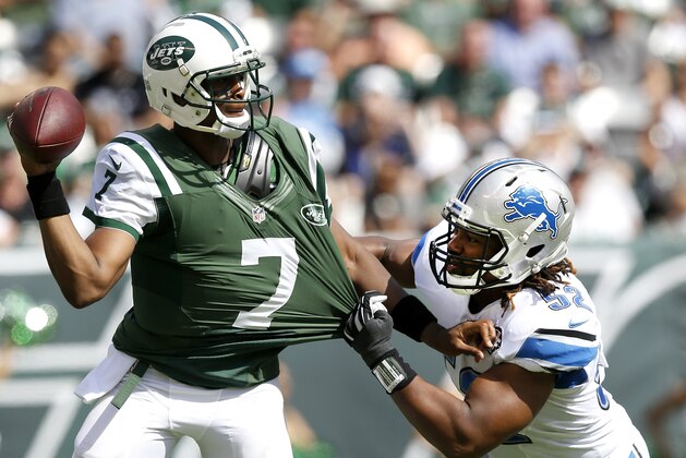 Detroit Lions defensive end Darryl Tapp, right, tugs at the jersey of New York Jets quarterback Geno Smith during the first half of an NFL football game, Sunday, Sept. 28, 2014, in East Rutherford, N.J. (AP Photo/Kathy Willens)