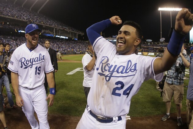 Kansas City Royals' Christian Colon (24) and Erik Kratz celebrate after their 9-8 win in the AL wild-card playoff baseball game against the Oakland Athletics Wednesday, Oct. 1, 2014, in Kansas City, Mo. (AP Photo/Charlie Riedel)