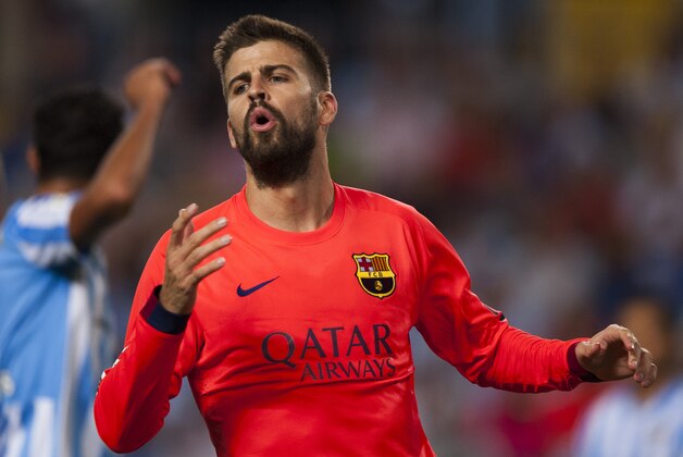FC Barcelona's Gerard Pique, gestures during a Spanish La Liga soccer match between Malaga and Barcelona at La Rosaleda stadium in Malaga, Spain, Wednesday, Sept. 24, 2014. (AP Photo/Daniel Tejedor)