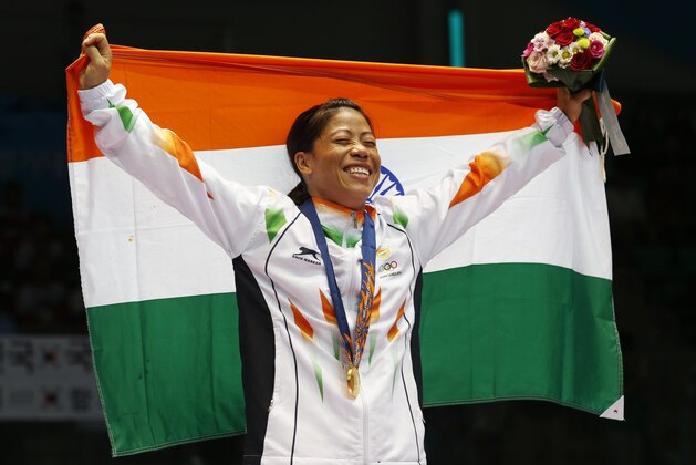 India’s M.C. Mary Kom holds the Indian national flag and celebrates her gold medal in the women’s flyweight (48-51kg) final boxing match at the 17th Asian Games in Incheon, South Korea, Wednesday, Oct. 1, 2014. (AP Photo/Kin Cheung)