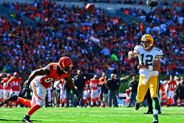Sep 22, 2013; Cincinnati, OH, USA; Green Bay Packers quarterback Aaron Rodgers (12) throws a pass while being pressured by Cincinnati Bengals defensive end Michael Johnson (93) during the third quarter at Paul Brown Stadium. Mandatory Credit: Andrew Weber-USA TODAY Sports