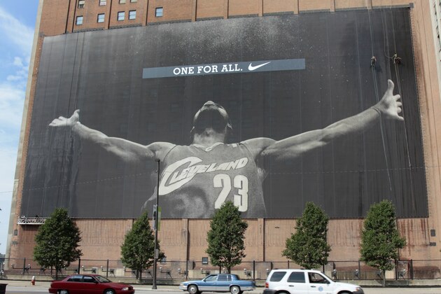 Workers clean the giant banner of Cleveland Cavaliers star LeBron James on a building facing the team's home court at Quicken Loans Arena in Cleveland, on Tuesday, June 22, 2010. (AP Photo/Amy Sancetta)