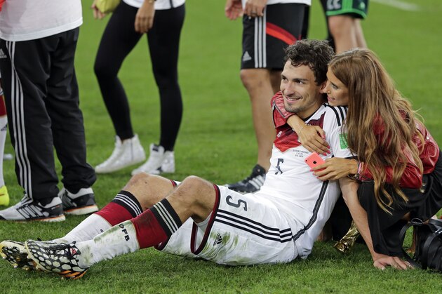Germany's Mats Hummels is embraced by his partner Cathy Fischer after the World Cup final soccer match between Germany and Argentina at the Maracana Stadium in Rio de Janeiro, Brazil, Sunday, July 13, 2014. Germany won the match 1-0. (AP Photo/Matthias Schrader)