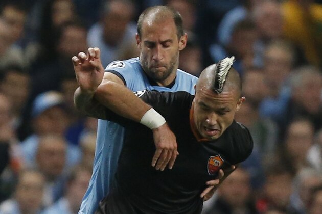 Manchester City's Pablo Zabaleta, left, holds Roma's Radja Nainggolan as he tries to control the ball during a Champions League group E soccer match between Manchester City and Roma at the Etihad Stadium, Manchester, England, Tuesday, Sept. 30, 2014. (AP Photo/Jon Super)
