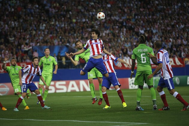 Atletico's Tiago, centre out jumps Juventus' Fernando Lloriente during the Group A Champions League soccer match between Atletico de Madrid and Juventus at the Vicente Calderon stadium in Madrid, Spain, Wednesday Oct. 1, 2014. (AP Photo/Andres Kudacki)